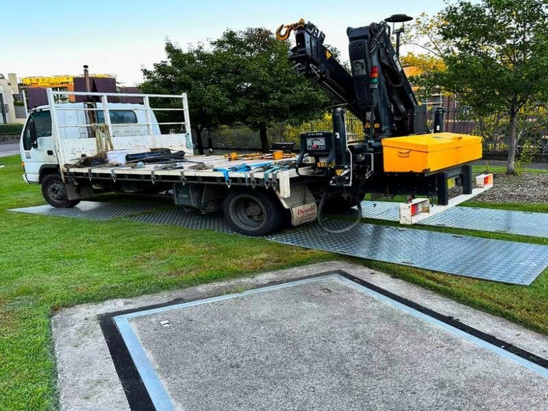 Standard Industrial Floor Mats A stack of black heavy-duty ground protection mats on a pallet